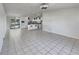 Open concept living room and kitchen with tiled floors, white cabinets and modern appliances and neutral paint at 2936 Woodcrest Ln, Lakeland, FL 33805