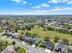 This aerial view highlights a community with sprawling green spaces, mature trees, and well-spaced homes under a partly cloudy sky at 3624 Belle Rose Dr, Leesburg, FL 34748