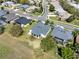 An aerial view highlighting a home with a screened-in lanai and beautiful landscaping in a suburban neighborhood at 3624 Belle Rose Dr, Leesburg, FL 34748