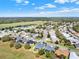 A picturesque aerial view of a suburban neighborhood with well-maintained homes and green spaces under a partly cloudy sky at 3624 Belle Rose Dr, Leesburg, FL 34748