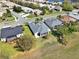 An aerial view of a home featuring a screened patio, surrounded by a lush green lawn and mature trees at 3624 Belle Rose Dr, Leesburg, FL 34748