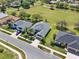 Aerial view showcasing a residential neighborhood with manicured lawns, mature trees, and proximity to a green field at 3624 Belle Rose Dr, Leesburg, FL 34748