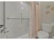 Bathroom with shower/tub combo, toilet, tile floors, and shower curtain at 3624 Belle Rose Dr, Leesburg, FL 34748