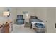 Cozy bedroom featuring a comfortable bed, recliner and a well-lit desk, creating a relaxing and functional space at 3624 Belle Rose Dr, Leesburg, FL 34748