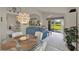 Open dining room with modern light fixture, leading to a living room and backyard view at 3624 Belle Rose Dr, Leesburg, FL 34748
