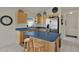 Kitchen features light wood cabinets, blue countertops, stainless steel appliances, and a breakfast bar at 3624 Belle Rose Dr, Leesburg, FL 34748