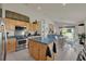 Kitchen features light wood cabinets, blue countertops, stainless steel appliances, and seamless transition to living area at 3624 Belle Rose Dr, Leesburg, FL 34748
