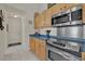 Kitchen featuring stainless steel appliances, light wood cabinetry, and blue countertops at 3624 Belle Rose Dr, Leesburg, FL 34748