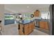 Open kitchen with an island and stainless steel appliances, connected to the dining and living areas at 3624 Belle Rose Dr, Leesburg, FL 34748