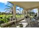 Relaxing lanai featuring an outdoor dining area and scenic backyard views with a mature palm tree at 3624 Belle Rose Dr, Leesburg, FL 34748