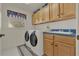 Practical laundry room with modern washer, dryer, utility sink, and ample cabinet space for storage at 3624 Belle Rose Dr, Leesburg, FL 34748