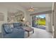 Bright living room featuring comfortable blue seating and sliding glass doors to the backyard at 3624 Belle Rose Dr, Leesburg, FL 34748