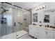 Remodeled bathroom featuring double vanity sinks, a spacious frameless glass shower, and modern fixtures at 380 Dorset Ave, Deltona, FL 32738