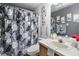 Bathroom with floral shower curtain, vanity with sink, and decorative mirror and wall art at 380 Dorset Ave, Deltona, FL 32738