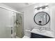 Bathroom featuring a tiled shower, a modern sink and vanity with round mirror and modern lighting at 459 Tivoli Cir, Davenport, FL 33837