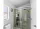 Bright bathroom features a glass-enclosed shower with tiled walls, and a window with privacy glass at 459 Tivoli Cir, Davenport, FL 33837