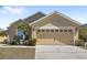 Charming single-Gathering home featuring a beige exterior, two-car garage, and well-maintained landscaping at 459 Tivoli Cir, Davenport, FL 33837