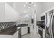 Well-lit kitchen featuring stainless steel appliances, granite countertops, and stylish tile flooring at 459 Tivoli Cir, Davenport, FL 33837
