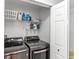 Functional laundry room featuring a washer, dryer, shelving, and a doorway to additional space at 459 Tivoli Cir, Davenport, FL 33837