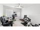 Spacious office setup with a gaming chair, multiple monitors, an exercise bike, and plenty of natural light at 459 Tivoli Cir, Davenport, FL 33837