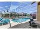 Beautiful pool area with screened enclosure, lounge chairs, and outdoor dining set, perfect for relaxation and entertainment at 459 Tivoli Cir, Davenport, FL 33837