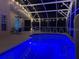 Inviting screened-in pool illuminated with blue lights and several seating areas for relaxation and gatherings at 459 Tivoli Cir, Davenport, FL 33837