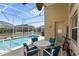 Outdoor pool area featuring an in-ground pool with screened enclosure, table, chairs, and blue accents at 459 Tivoli Cir, Davenport, FL 33837