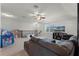 Spacious living room with a grey sectional sofa, a ceiling fan, and neutral carpet at 4631 Cypress Forest Ln, St Cloud, FL 34772