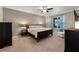 Comfortable bedroom with a large bed, ceiling fan, and a window with blue curtains at 4631 Cypress Forest Ln, St Cloud, FL 34772