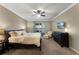 Comfortable bedroom with a large bed, ceiling fan, and a window with blue curtains at 4631 Cypress Forest Ln, St Cloud, FL 34772