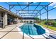 Backyard featuring a sparkling in-ground pool enclosed by a screen, surrounded by a well-maintained patio and green landscaping at 4631 Cypress Forest Ln, St Cloud, FL 34772