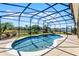 Beautiful in-ground pool enclosed by a screen, set in a well-maintained backyard with green landscaping and privacy fencing at 4631 Cypress Forest Ln, St Cloud, FL 34772