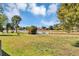 Large green backyard with a lake and trees surrounding the area on a beautiful sunny day at 5307 Sandy Hill Dr, Orlando, FL 32821