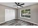 This bedroom has plank floors, a ceiling fan, and a window at 5307 Sandy Hill Dr, Orlando, FL 32821