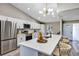 Bright kitchen with stainless steel appliances, a large quartz island, and a modern light fixture at 5307 Sandy Hill Dr, Orlando, FL 32821