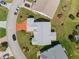 Overhead aerial view of a home with a well-manicured lawn, mature landscaping, and a three-car garage at 5414 Zinnia St, Leesburg, FL 34748