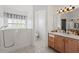 Bright bathroom featuring a walk-in tub, a toilet in its own room, and a sink with vanity at 5414 Zinnia St, Leesburg, FL 34748