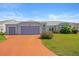 Charming single-story home featuring a three-car garage, mature landscaping, and a colorful driveway at 5414 Zinnia St, Leesburg, FL 34748