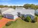 Aerial view of a home with a three-car garage, an eye-catching driveway, and established landscaping at 5414 Zinnia St, Leesburg, FL 34748