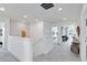 Bright upstairs hallway leading to open areas, featuring neutral carpeting and recessed lighting at 6033 Tree Crossing Ln, St Cloud, FL 34771
