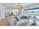 Open-concept living area with a large sofa, sliding glass doors to patio, and a view of the modern kitchen at 6033 Tree Crossing Ln, St Cloud, FL 34771