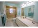 Bathroom with white tiled floors, vanity, toilet, and tub/shower with gold trimmed sliding glass doors at 613 Andrew St, Altamonte Springs, FL 32714