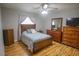Comfortable bedroom featuring a ceiling fan, wood floors, and plenty of natural light from the window at 613 Andrew St, Altamonte Springs, FL 32714