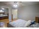 Cozy bedroom showcasing a ceiling fan, hardwood floors, and a mirrored closet, offering comfort and functionality at 613 Andrew St, Altamonte Springs, FL 32714