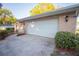 Attached garage with white door and brick facade, complemented by well-maintained landscaping for a welcoming curb appeal at 613 Andrew St, Altamonte Springs, FL 32714
