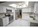 Bright kitchen with white cabinets, stainless steel appliances, and a decorative, illuminated ceiling at 613 Andrew St, Altamonte Springs, FL 32714