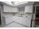 Modern kitchen featuring white cabinets, stainless steel sink, and marble floors at 613 Andrew St, Altamonte Springs, FL 32714