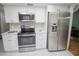 Modern kitchen with stainless steel appliances, white cabinets, and marble floors at 613 Andrew St, Altamonte Springs, FL 32714