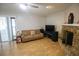 Cozy living room with wood laminate floors, a stone fireplace, neutral paint, and sliding glass doors for ample natural light at 613 Andrew St, Altamonte Springs, FL 32714