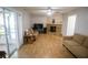 Cozy living room with wood laminate floors, a stone fireplace, neutral paint, and sliding glass doors for ample natural light at 613 Andrew St, Altamonte Springs, FL 32714